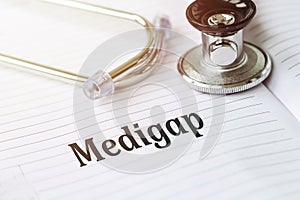 MEDIGAP text on white paper on the medical background with stethoscope