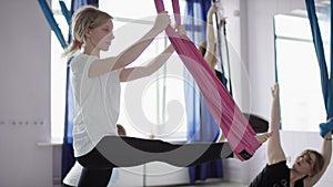 Meditates and harmony concept, Caucasian woman making antigravity fly yoga exercises in hammock yoga studio.