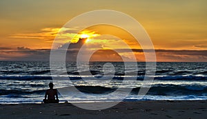 Meditating on the beach at sunrise