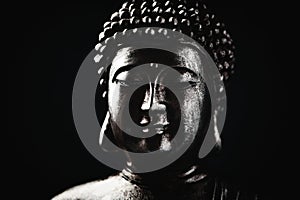 Meditating Buddha Statue on dark background. Close up.