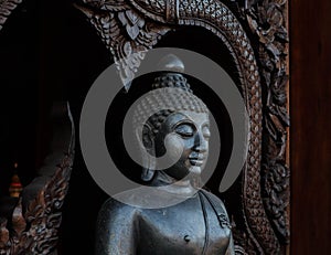 Meditating Buddha Statue on dark wooden background. Close up