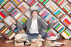 Meditating man in the library with books on head
