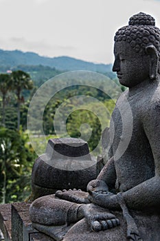 Meditating sitting Buddha sculputre in stone at