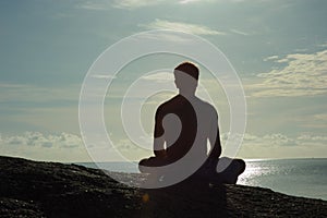 Meditating at Sunrise Overlooking Ocean photo