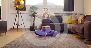 Meditating whole sitting cross legged on carpet. Beautiful woman relaxing