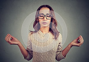 Meditating woman in glasses with eyes closed
