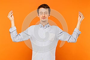 Meditation, mental practice. Young adult man closed eyes and doing yoga