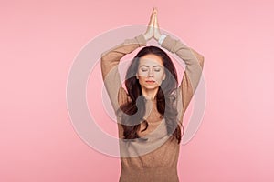 Meditation, mind balance. Portrait of peaceful concentrated young woman holding hands in namaste gesture
