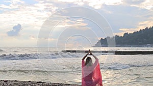 Meditation near the sea and doing yoga on a beach at sunrise