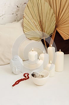 Meditation place with candles and smudge stick in yoga studio
