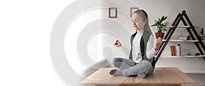 Meditation and relaxation of a little teen sitting on a desk in a lotus position with her legs crossed. Pupil relax rest