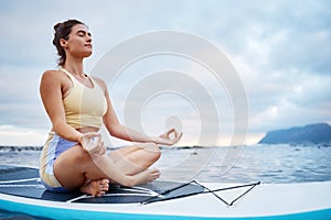 Meditation, surf and sea with a woman on a surfboard floating out in nature with a cloudscape and mockup. Yoga, ocean