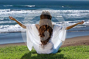 Meditation of woman against ocean