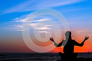 Meditation woman yoga silhouette, ocean during amazing sunset. Relax.