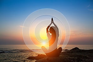 Meditation woman yoga silhouette on the Sea beach during amazing sunset.