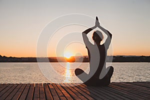 Meditation and yoga practice at sunset, silhouette of woman, calmness