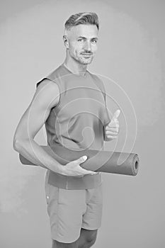 Meditations designed to help you find your joy. Man practicing yoga at home. Handsome sportsman with yoga mat. Workouts