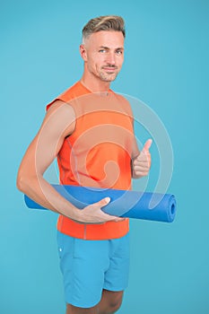 Meditations designed to help you find your joy. Man practicing yoga at home. Handsome sportsman with yoga mat. Workouts