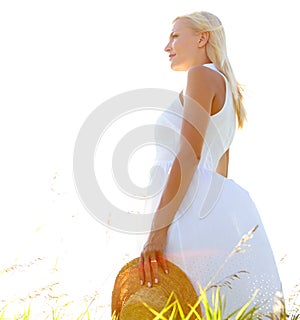 Meditations in the meadow. Profile of a gorgeous young woman standing in a meadow holding her sunhat.