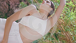 Meditative lady breathing exercises on exotic jungle vertical. Woman stretching