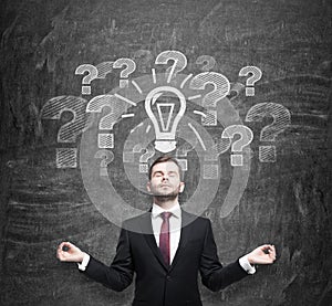 Meditative man is looking for the best business ideas to start a new business. Question marks and a light bulb are on the