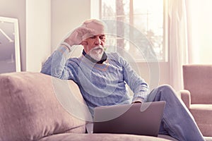 Meditative old man spending time with laptop