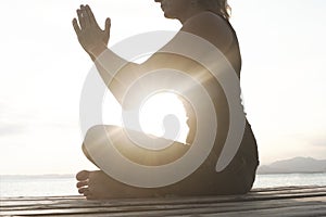 Meditative woman prays in front of the sea