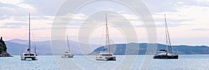 Mediterranean bay with sailing boats catamarans panoramic banner. Yachts on a sea, Corfu island, Greece.