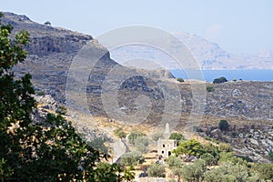 Mediterranean coast with the monument to Ioannis Zigdis in Lindos. Rhodes, Dodecanese, Greece