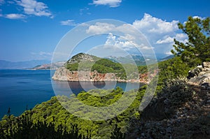 Mediterranean coast of Turkey, Peninsula with coastal cliff, deep blue sea water, lush green forest, sunny day, Picturesque