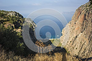 Mediterranean coast in Turkey, view of Butterfly Valley from Faralya, Lycian Way trail. Travel photo. Rocky cliff