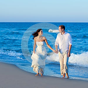 Mediterranean couple walking in blue beach