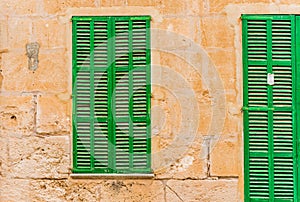 Mediterranean green wood window shutter and door with rustic stone wall