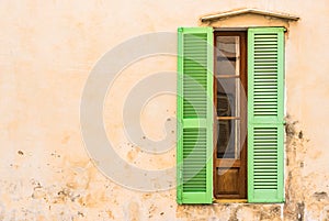 Mediterranean house with open green window shutter and plaster wall background