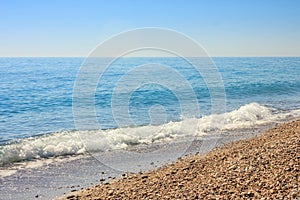 Mediterranean landscape in Antalya, Turkey. Blue sea, waves and pebble sandy beach