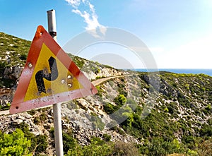 Mediterranean landscape with a road and a shooted traffic sign photo