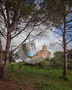 Mediterranean little chapel over a hill in the countryside. Menorca, Spain photo