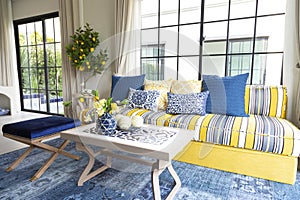 Mediterranean living room interior with bright yellow and blue sofa and pillow.