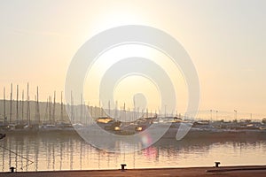 Mediterranean marina with sailing and motor yachts in the rays of the morning dawn. Sea touristic business. Infrastructure of the
