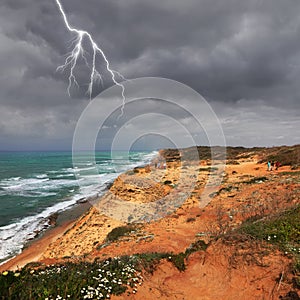 Mediterranean sea panoramic landscape with high sandy cliff coast. Lightning sparkling in thunder sky