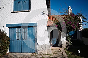 Mediterranean style house with white walls, orange tiles and blue shutters