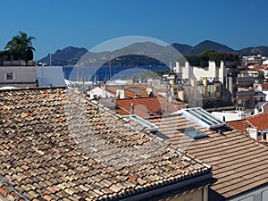 Mediterranean style shingle tiles are seen on rooftops Cannes, France, Europe Old Cannes in distance of harbor