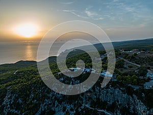 Mediterranean sunset from the Agalas viewpoint. Sitting and watching sunset in Zakynthos, Greece. Sunset pine trees, olive groves