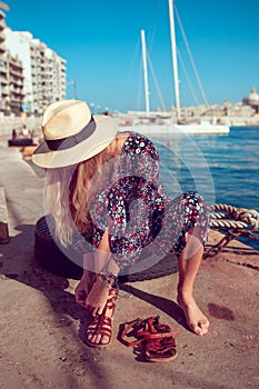 Mediterranean woman put on shoes at sea