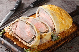 Medium Beef Wellington classic sliced steak closeup on wooden board. Horizontal