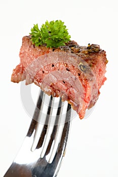 Medium grilled rumpsteak on a fork