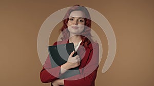 Medium isolated video of a satisfied, happy and active young woman holding a folder, planchette in her hands and smiling