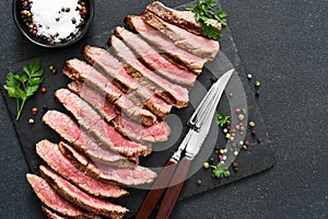 Medium meat. Grilled steak with provencal herbs on a stone board photo