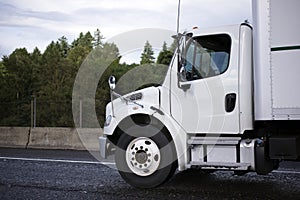 Medium power class semi truck with box trailer on the road