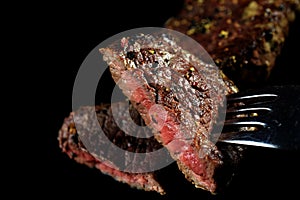 Medium rare beef steak piece on a fork